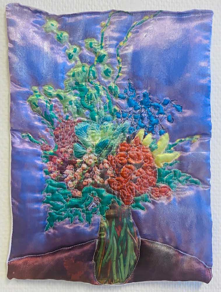 "Lila blomma" är ett konstverk av Moa-Matilda Nilsson. Det är digitaltryck på polyester, med quiltning och broderi gjort 2025 i ett unikt exemplar och mäter 32 x 24 cm.