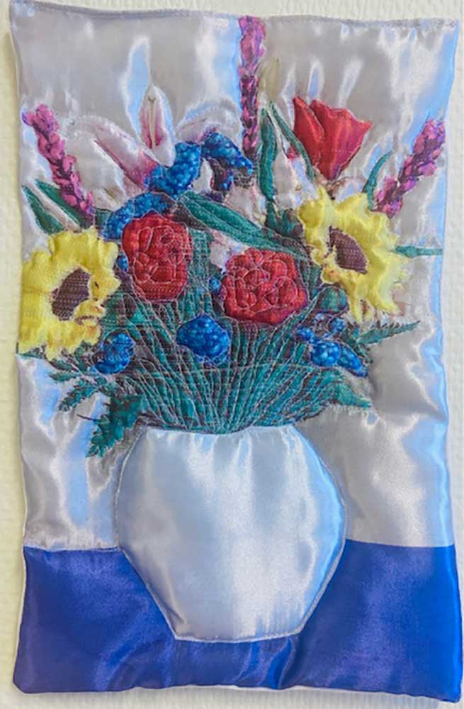 "Vit blomma" är ett konstverk av Moa-Matilda Nilsson. Det är digitaltryck på polyester, med quiltning och broderi gjort 2025 i ett unikt exemplar och mäter 31 x 20 cm.