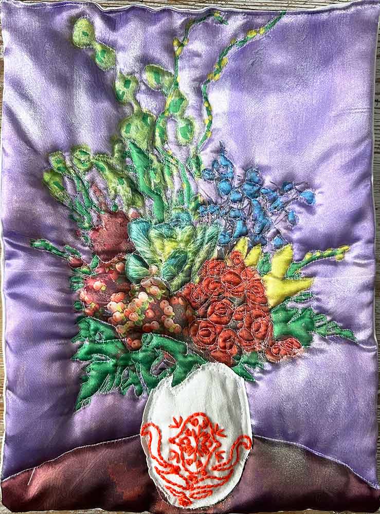 "Lila blomma med broderi" är ett konstverk av Moa-Matilda Nilsson. Det är digitaltryck på polyester, med quiltning och broderi gjort 2025 i ett unikt exemplar och mäter 33 x 25 cm.